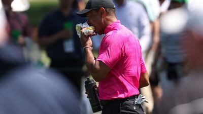 Woods eats a sandwich on the 8th fairway. Reuters