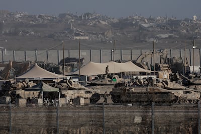Israeli army personnel gather near military vehicles and heavy machinery along the border with Gaza. Reuters
