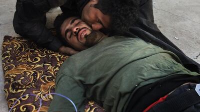 WARDAK, IRAQ: A peshmerga comforts his wounded comrade.