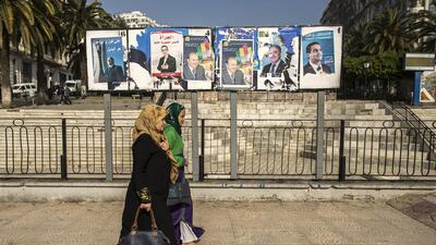Women walk past campaign election posters in Algiers. The Algerian presidential election will be held on Thursday. Zohra Bensemra / April 16, 2014