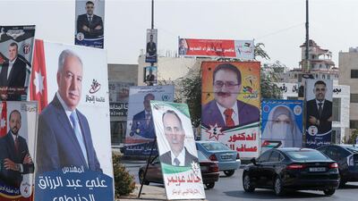 Cars advance on a road lined with campaign banners and slogans of candidates for the upcoming Jordanian parliamentary elections in the capital Amman. AFP