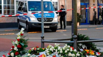 A police car is seen behind flowers placed at a makeshift memorial for the victims of the Hanau shooting in front of a shisha bar in Hanau near Frankfurt am Main, western Germany. Thousands of people took part in vigils across Germany on February 20, 2020, after a gunman with apparent far-right beliefs killed nine people at a shisha bar and a cafe in the city of Hanau on February 19, 2020. The suspect, a 43-year-old German, was found dead at his home after the rampage along with his 72-year-old mother in what appeared to be a murder-suicide. AFP