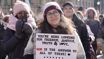 A woman holds a religious sign at the anti-vaccine protest in Ottawa. Willy Lowry / The National