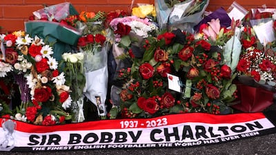 Flowers and a scarf laid outside Old Trafford as a tribute to Sir Robert Charlton. Getty Images