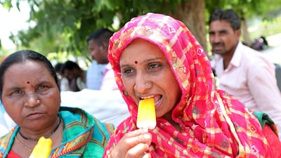 Indian women eat ice lollies in New Delhi. The India Meteorological Department has issued a heat red alert for Delhi, Rajasthan, Haryana, Punjab and Madhya Pradesh. EPA
