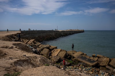 Palestinians walk by a pier that could be used to bring humanitarian aid into Gaza. AP