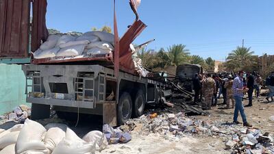 Iraqi soldiers inspect the wreckage of a lorry used to launch rockets at US forces at Ain Al Asad air base in July. EPA