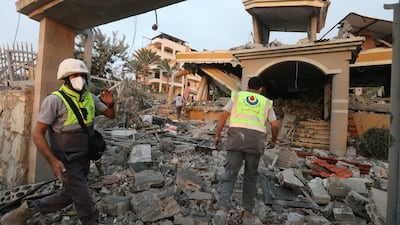 Rescuers inspect a house damaged by an Israeli air strike in the town of Tayr Debba. EPA