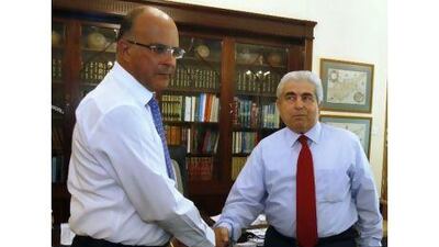 Cypriot president Demetris Christofias, right, shakes hands with coalition partner Marios Karoyan, chairman of the Democratic Party (DIKO), at the presidential palace in Nicosia yesterday, Andreas Manolis / Reuters