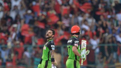 Virat Kohli, left, celebrates reaching his century alongside Royal Challengers Bangalore teammate AB de Villiers. Manjunath Kiran / AFP