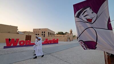 People walk past FIFA World Cup banners at a beach in Doha ahead of the Qatar 2022 FIFA World Cup football tournament. AFP