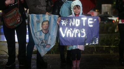 A girl holds a banner that shows a Spanish hashtag “Lio don’t leave”.