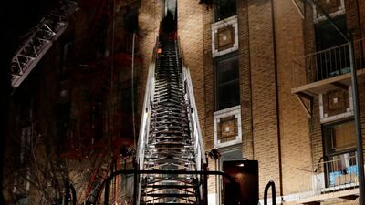 Firefighters climb a ladder to the five-storey building where a fire broke out at about 7pm on December 28, 2017 in the Bronx borough of New York. Frank Franklin II / AP Photo