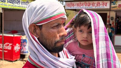 A man and a child covered with scarves to shield themselves from the blazing sunshine in Lalitpur, Uttar Pradesh state