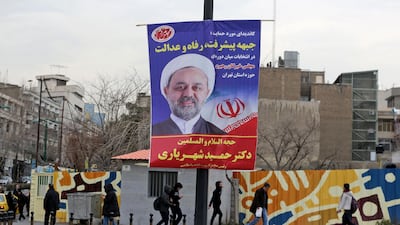Iranians walk past electoral posters and fliers during the last day of election campaign in the capital Tehran. AFP