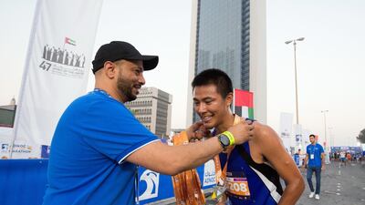 Participant who finishes at the 10km marathon getting his medal at the Adnoc Abu Dhabi Marathon. Leslie Pableo for The National