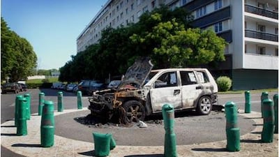 A burnt-out car next to the infamous housing project Quatre Mille in the Paris suburb of La Courneuve, where immigrants have clashed with police.
