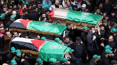Mourners carry coffins during the funeral procession. Reuters