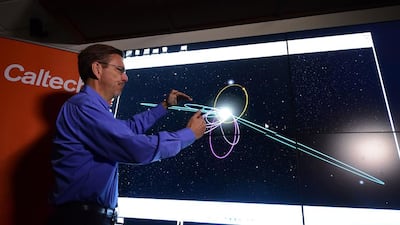 Astronomer Michael E Brown demonstrates the predicted orbit, in yellow, of the ninth planet at a Caltech seismology lab in California. He and colleague Konstantin Batygin reported ‘good evidence’ of a ninth planet on the fringes of the Solar System. Frederick J Brown / AFP