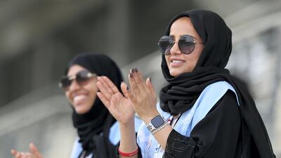 Volunteers cheer on the athletes during the 5km time trial during the cycling at the Special Olympics.
