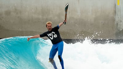 Founder of the Wave, Nick Hounsfield, holds the baton as he surfs at the centre in Bristol. PA