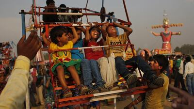 Indian children react as they experience a ride at a fairground before the burning of effigies of demon King Ravana, during Dussehra celebrations on the outskirts of New Delhi, India. Altaf Qadri / AP Photo