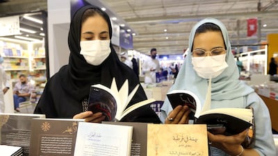 Two Saudi women look at a book during the Riyadh International Book Fair in Riyadh, Saudi Arabia, October 2, 2021. Picture taken October 2, 2021. REUTERS / Ahmed Yosri