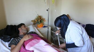 A Lebanese nurse, right, treats a Syrian man at a Lebanese medical charity clinic in the northern port city of Tripoli on Wednesday. Syrian refugees in Lebanon lack access to specialised medical care such as dialysis and cancer treatment, according to a new report from Amnesty International. AP Photo