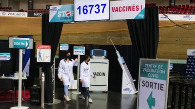 Healthcare workers pass exit signs at the Covid-19 vaccination center inside France's national velodrome in the Saint-Quentin-en-Yvelines district of Paris. Bloomberg