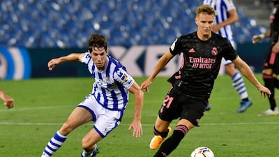 Real Madrid midfielder Martin Odegaard fights for the ball against Real Sociedad's Aritz Elustondo. AP Photo