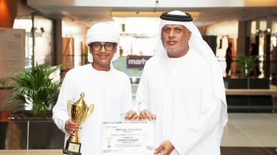 Khamis shows off his trophy and certificate alongside his father. Pawan Singh / The National