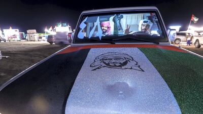Lafi Al Merri, left, and his cousin Shafi Al Merri, right, get takeaway tea on Millions Street at the Al Dhafra Festival. Victor Besa / The National