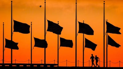 Runners pass under flags flying at half-mast around the Washington Monument. J David Ake / AP Photo