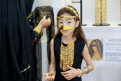 A young Chinese visitor wears traditional Emirati jewellery after having henna applied at Al Bait Al Emarati. Photo: Abu Dhabi Heritage Authority