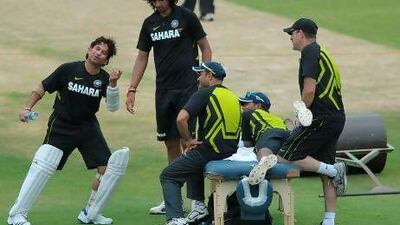 Indian cricketer Sachin Tendulkar (L) gestures with team members during a training session at the Rajiv Gandhi International cricket stadium in Hyderabad on August 21, 2012. New Zealand will play two Test matches and two Twenty20 matches against India. AFP PHOTO / Noah SEELAM *** Local Caption *** 283674-01-08.jpg