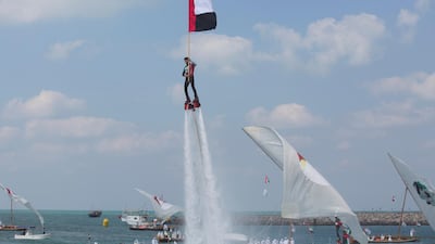The UAE flag is raised during an aquatic jet pack performance during National Day celebrations at the Breakwater in Abu Dhabi. Ryan Carter / Crown Prince Court - Abu Dhabi