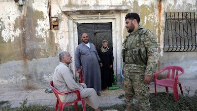 A Turkey-backed Syrian fighter speaks with poeple in the town of Tal Abyad, Syria. Reuters
