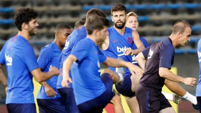 Gerard Pique, right, and his Barcelona teammates warm up during a training session at the Machida Municipal Athletic Stadium. AP Photo