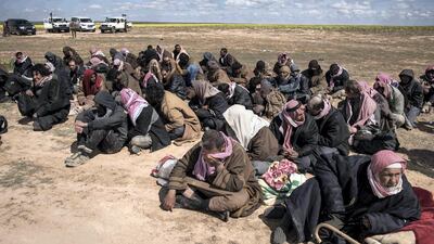 ISIS members waited to be processed after surrendering to the Syrian Democratic Forces outside Baghouz, Syria. Campbell MacDiarmid