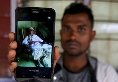 Muhammad Ayub, a Rohingya refugee in Malaysia, shows a picture of his grandfather he said was killed during recent violence in Myanmar. Daniel Chan / AP Photo
