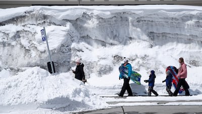 Residents walk to a bus stop covered in snow after a storm brought 30 inches of snow in less than 24 hours earlier in the week in Mammoth Lakes in California. The state received more than 700 inches of snow so far this season. EPA