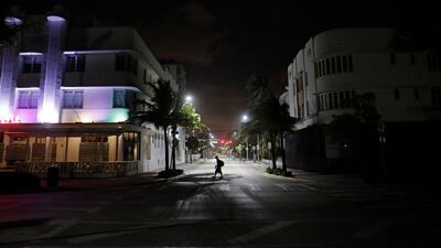 A lone pedestrian walks through the usually bustling South Beach ahead of Hurricane Irma in Miami Beach. Florida has asked 5.6 million people to evacuate ahead of Hurricane Irma, or more than one quarter of the state's population, according to state emergency officials. David Goldman / AP Photo