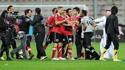 Majed Nasser, right, the Al Wasl goalkeeper, is confronted by Al Ahli players after he had shoved their manager, Quique Sanchez Flores, third left..