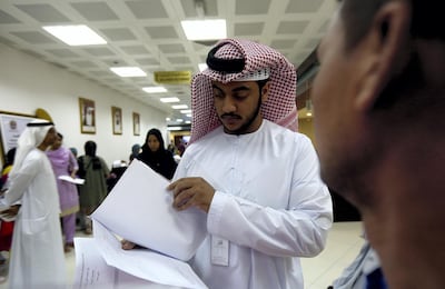 Khaled Al Maazmi, assistant deputy general director, check applicant papers at the Tasheel centre at Al Raha mall, Abu Dhabi. Satish Kumar / The National