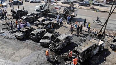 Municipality workers clear debris while citizens inspect the site of a car bomb attack in the Sha'ab neighborhood of Baghdad, Iraq. Karim Kadim / AP Photo