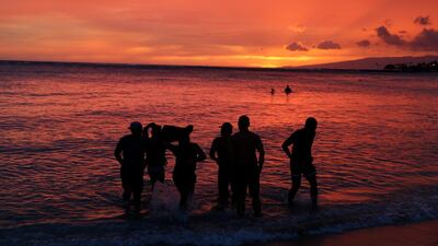 People watch the sunset on Waikiki Beach ahead of Hurricane Lane in Honolulu. John Locher / AP Photo