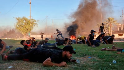 Anti-government protesters take cover while Iraq security forces fire during a demonstration in Baghdad, Iraq. AP