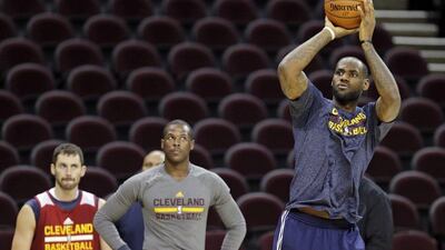 Cleveland's LeBron James takes practice shots on Wednesday ahead of the Cavaliers' season opening game against the Knicks on Thursday night. Mark Duncan / AP / October 29, 2014