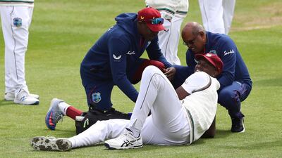 West Indies captain Jason Holder receives treatment after injuring his thumb trying trying the catch the ball. AP