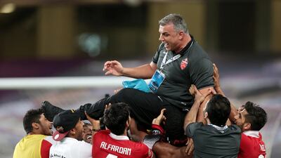 Al Ahli players lift coach Cosmin Olaroiu after advancing past Al Ain in the Asian Champions League last 16 to the quarter-finals. Christopher Pike / The National / May 27, 2015